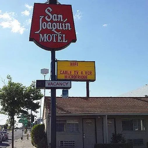 San Joaquin Motel Sign with free wifi cable tv and vcr and microfridge listed on a sunny day