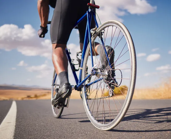 Outdoor recreation and road biking in the Central Valley, showing a cyclist riding past rural golden fields near Merced.