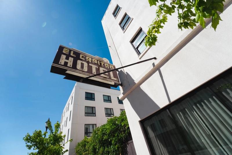 Vintage marquee sign reading "El Capitan Hotel" against a clear blue sky
