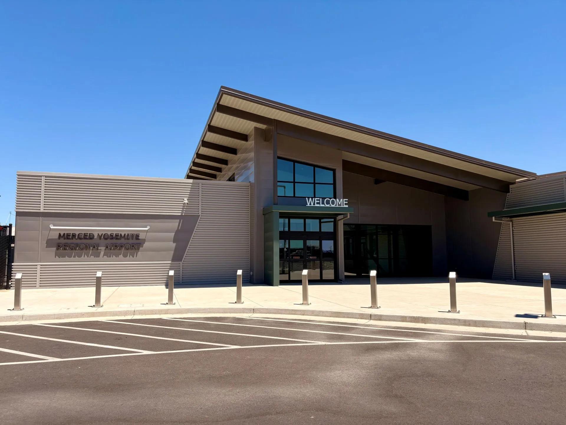 Merced Yosemite Regional Airport's terminal entrance under a clear blue sky